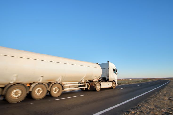 petrol cargo truck driving on highway hauling oil products. delivery transportation and logistics concept